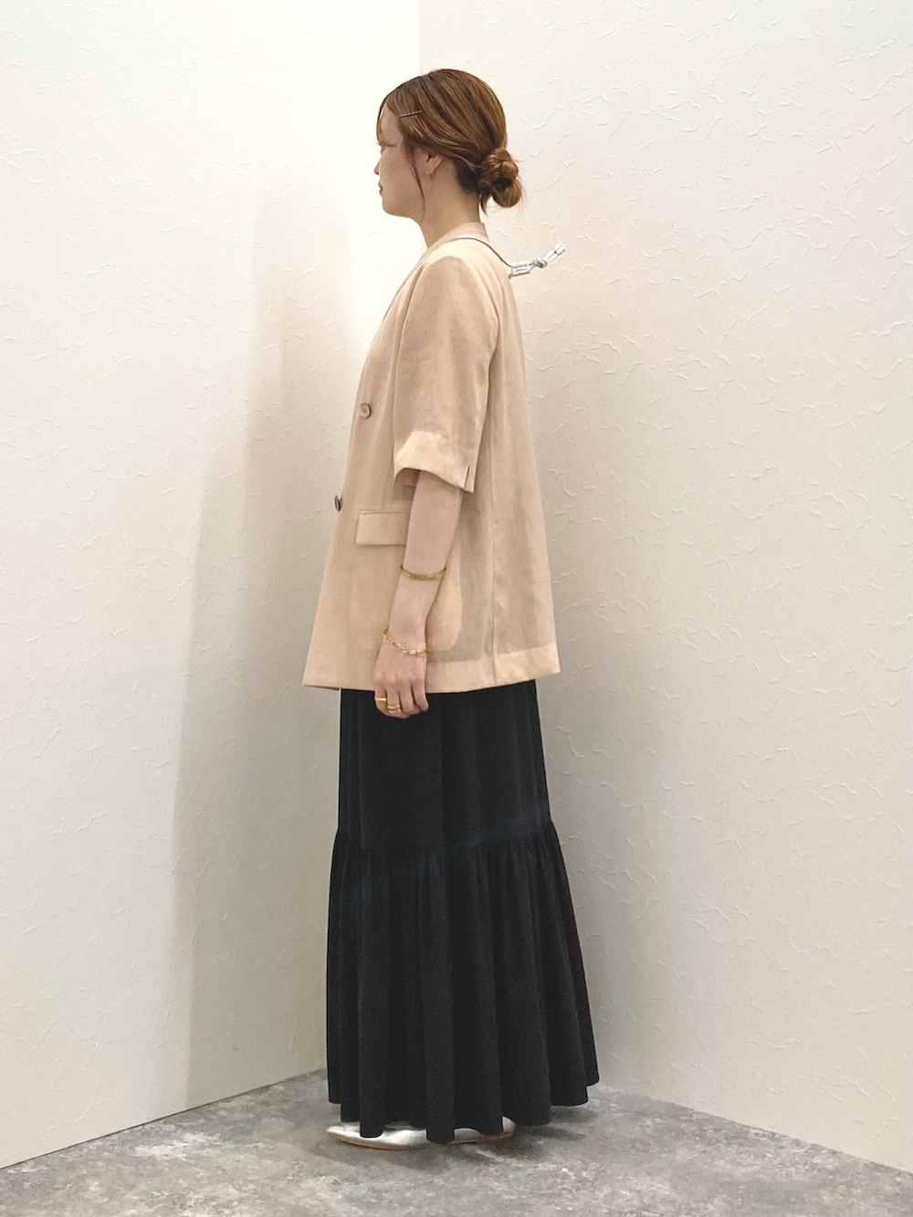 ブラック系のスカート、パープル系のショルダーバッグ、ベージュ系のノーカラージャケットを着用したレディースの夏コーディネートの3枚目の写真