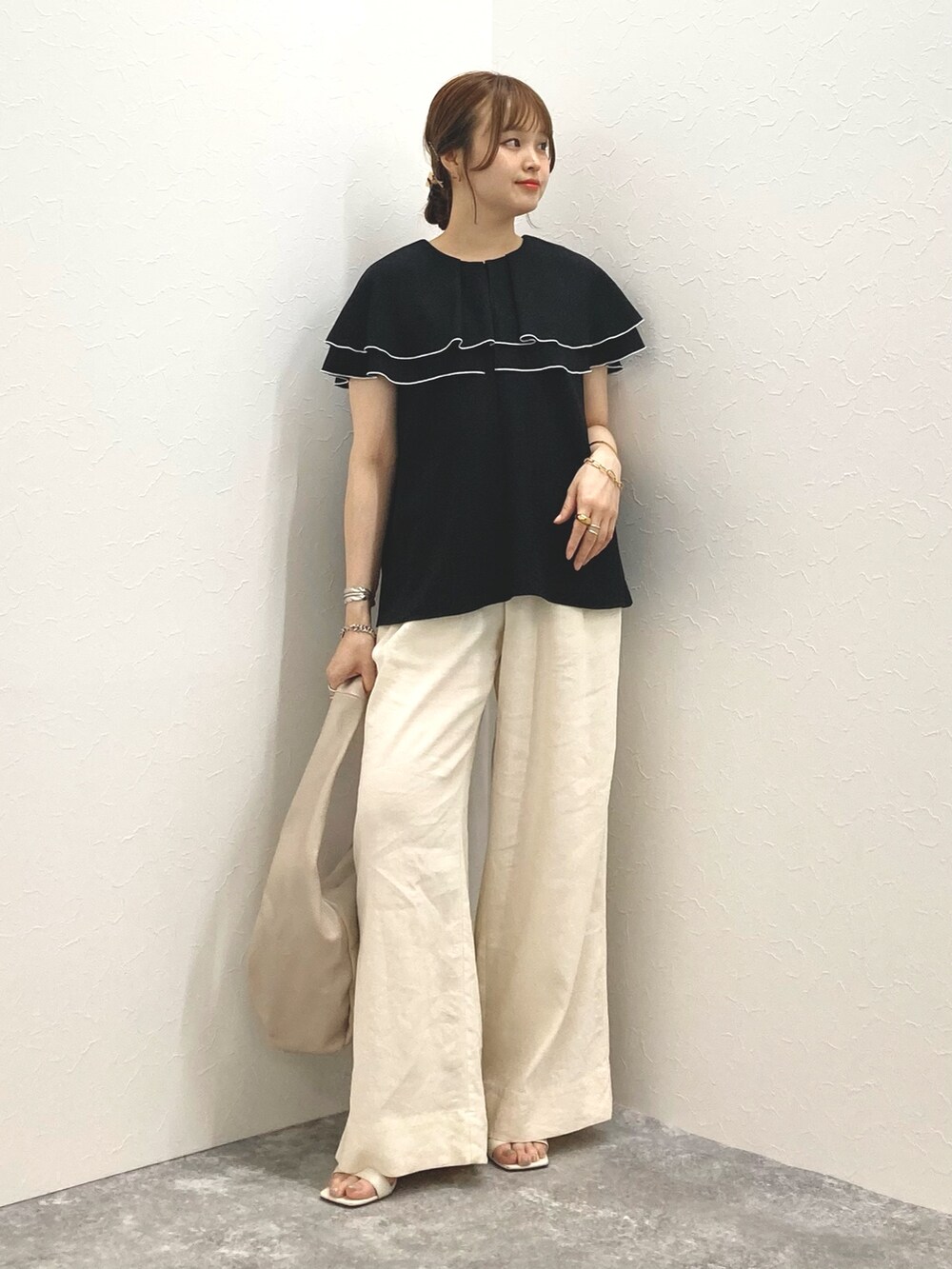 ブラック系のシャツ/ブラウス、ホワイト系のその他パンツ、ベージュ系のショルダーバッグを着用したレディースの夏コーディネートの2枚目の写真