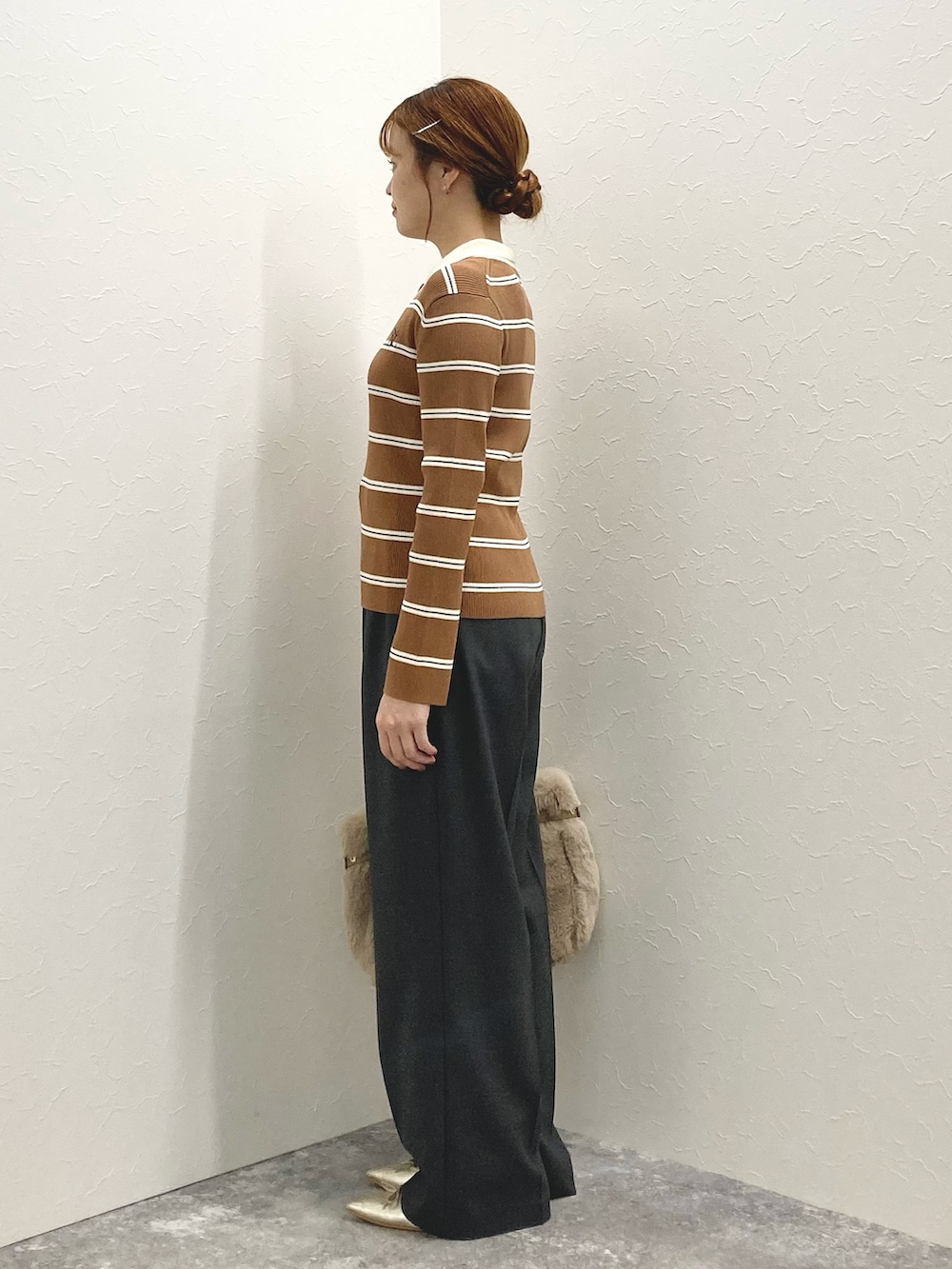 グレー系のその他パンツ、ブラウン系のニット/セーター、ベージュ系のトートバッグを着用したレディースの秋コーディネートの3枚目の写真