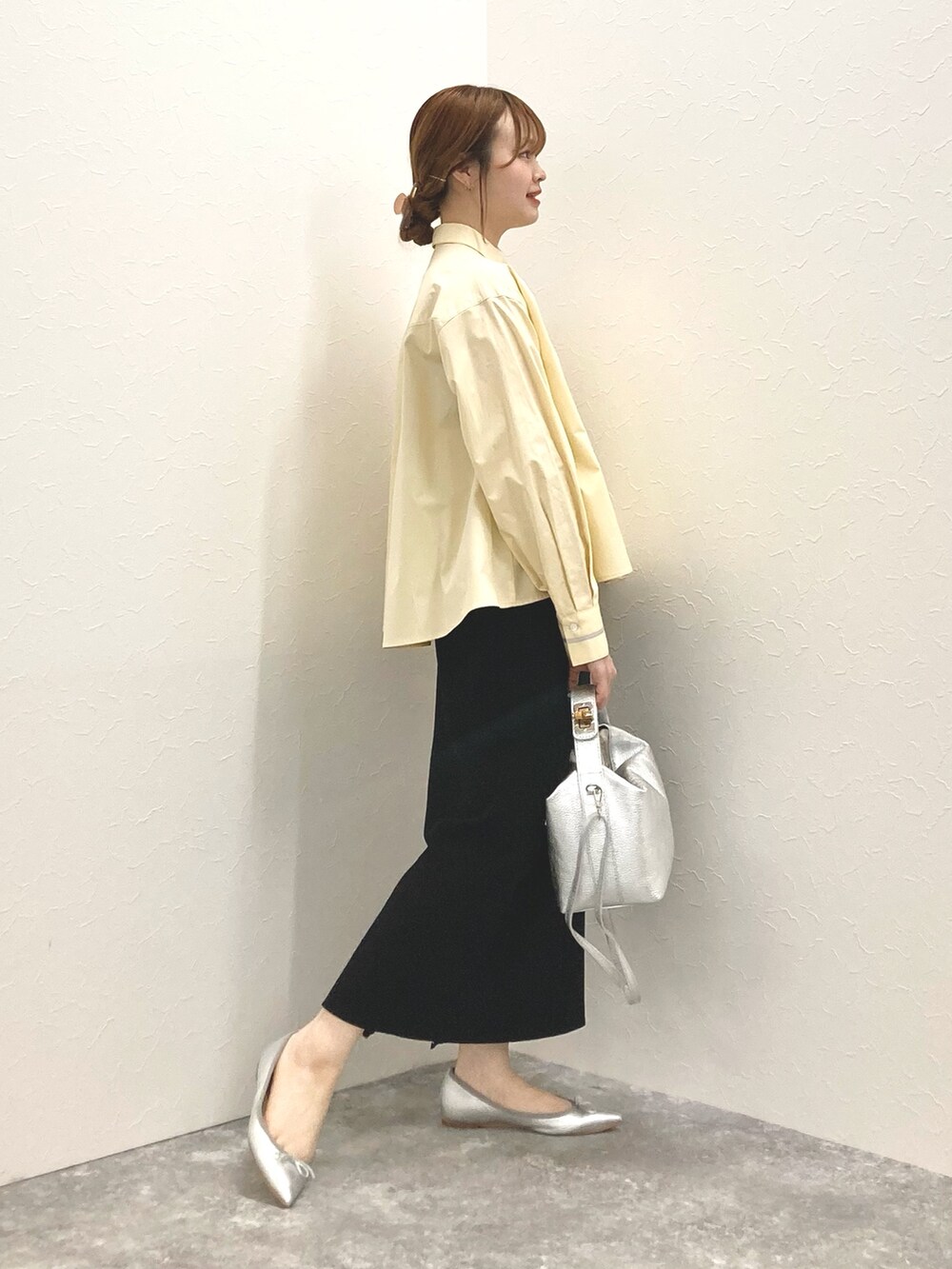 シルバー系のショルダーバッグ、イエロー系のシャツ/ブラウス、ブラック系のスカートを着用したレディースの春コーディネートの7枚目の写真