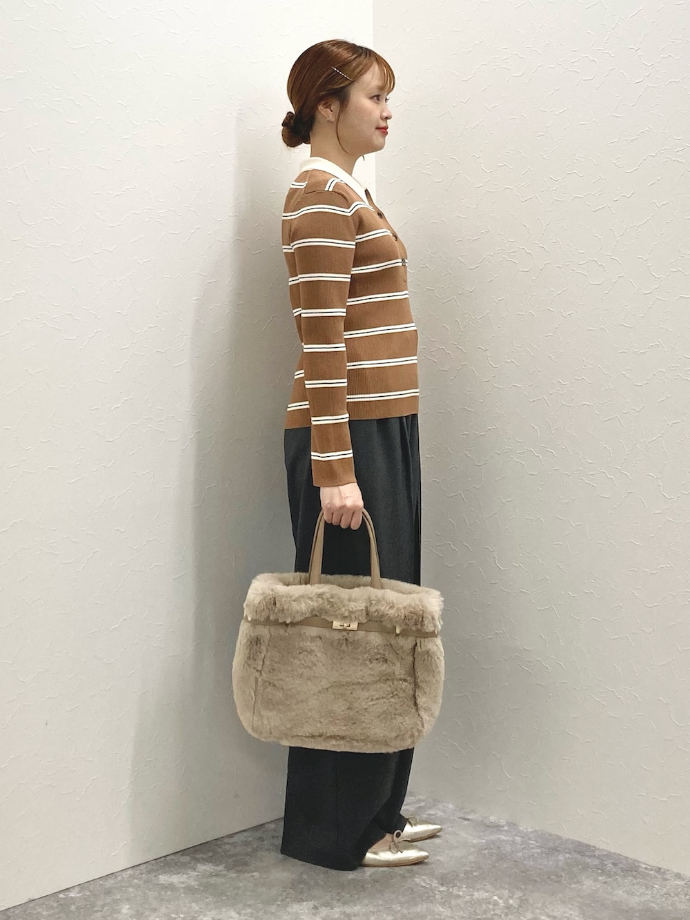 グレー系のその他パンツ、ブラウン系のニット/セーター、ベージュ系のトートバッグを着用したレディースの秋コーディネートの5枚目の写真