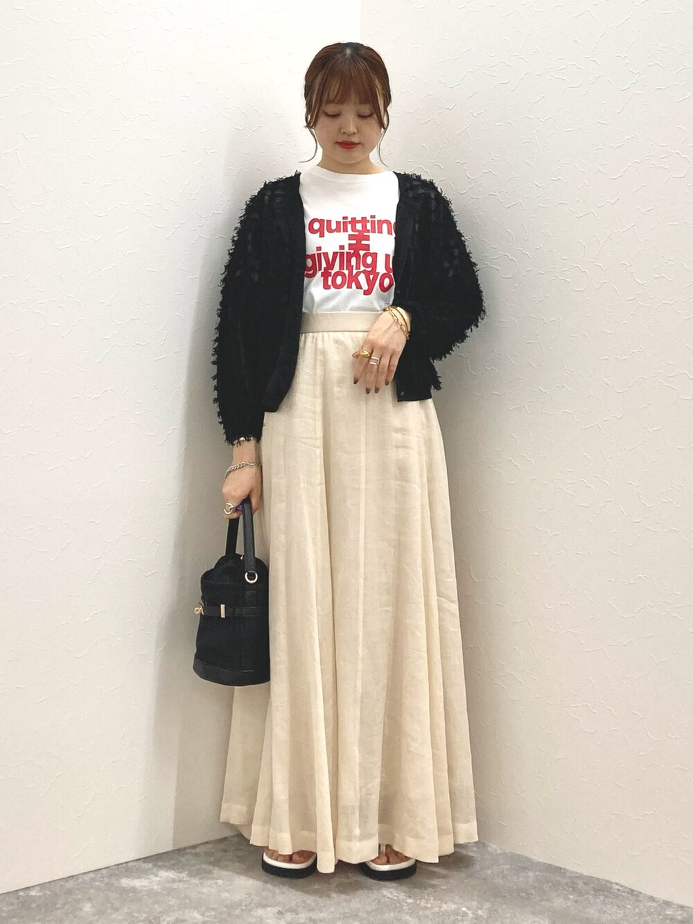 ホワイト系のTシャツ/カットソー、ベージュ系のスカート、ブラック系のカーディガン/ボレロを着用したレディースの夏コーディネートの8枚目の写真