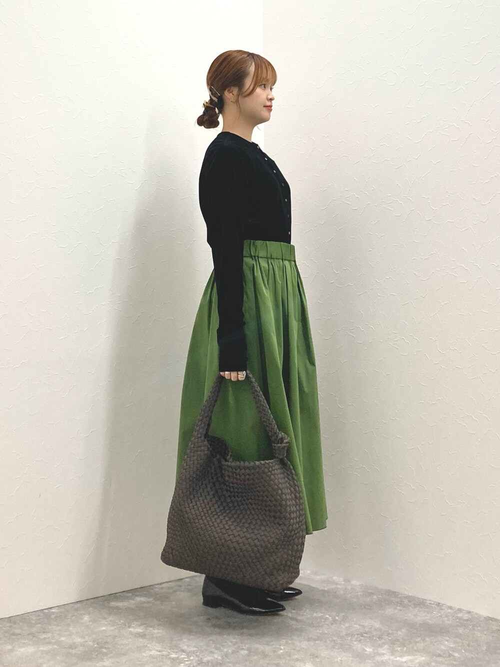 ブラック系のカーディガン/ボレロ、グリーン系のスカート、グレー系のショルダーバッグを着用したレディースの秋コーディネートの5枚目の写真