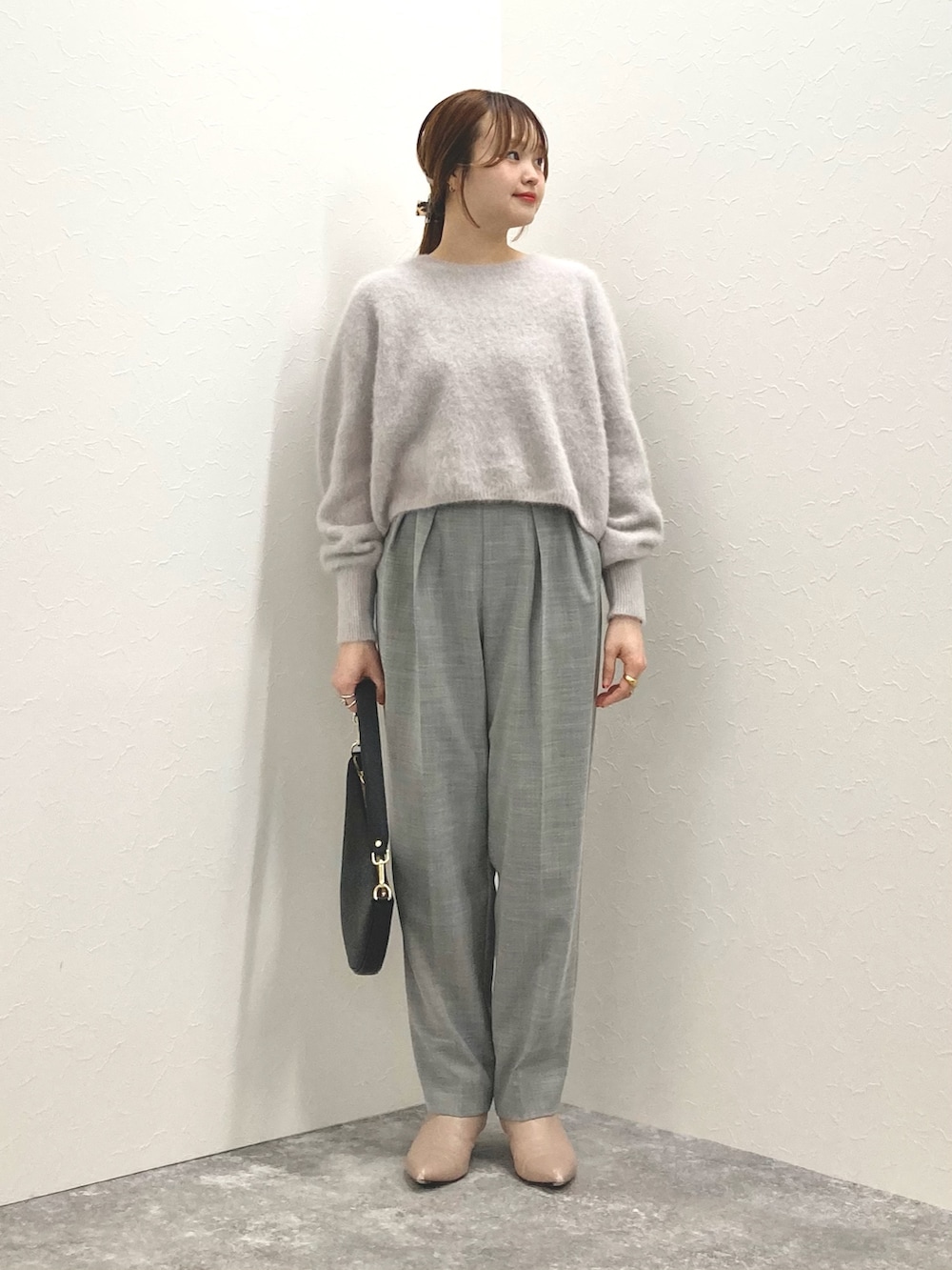 ベージュ系のニット/セーター、ブラック系のショルダーバッグ、グレー系のその他パンツを着用したレディースの冬コーディネートの2枚目の写真