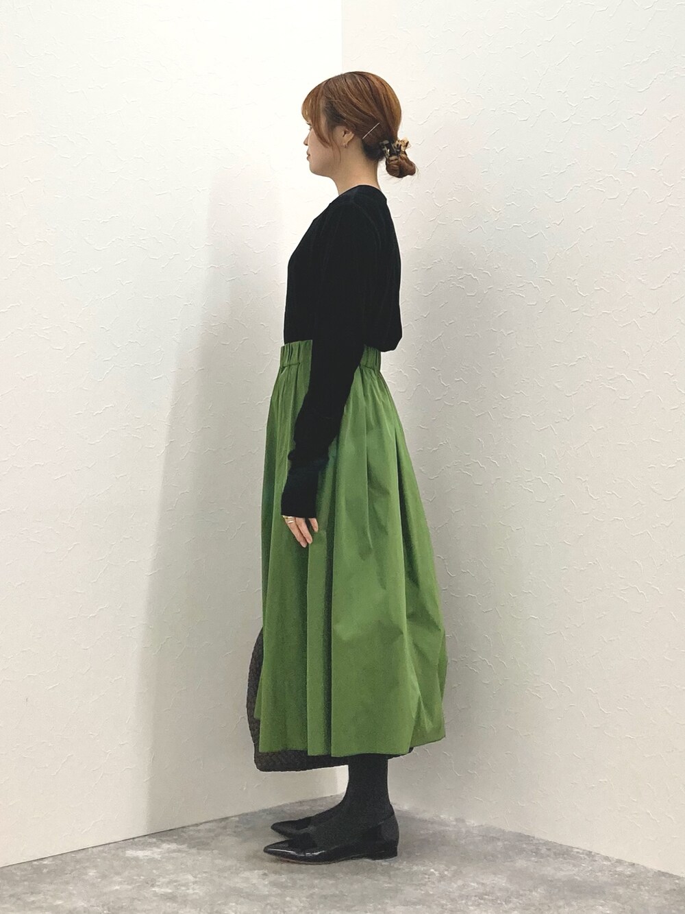 ブラック系のカーディガン/ボレロ、グリーン系のスカート、グレー系のショルダーバッグを着用したレディースの秋コーディネートの3枚目の写真