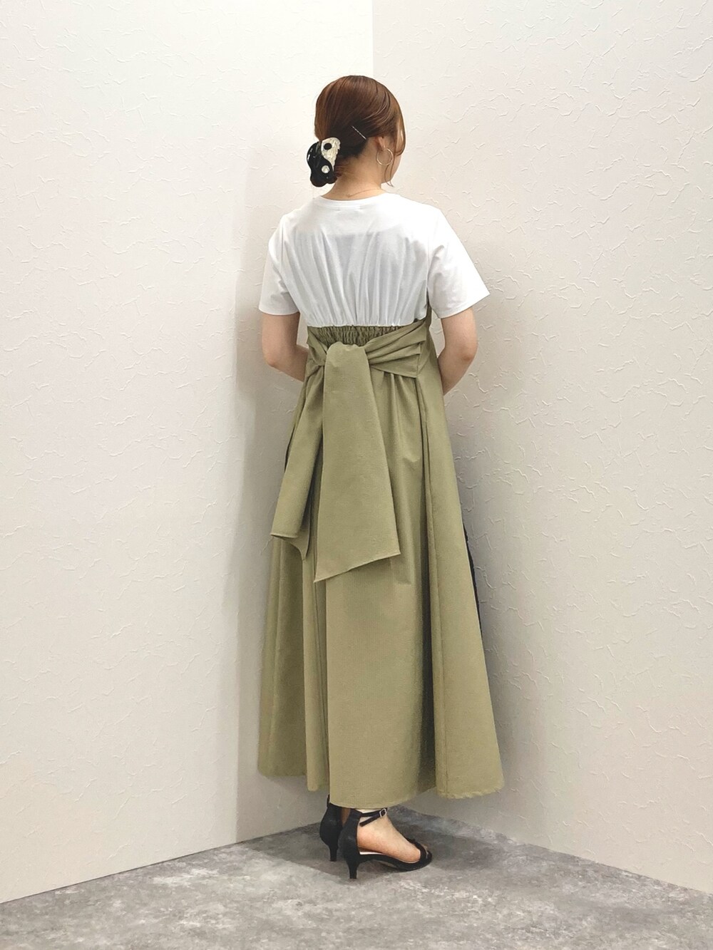 グリーン系のワンピース、ブラック系のサンダル、ブラック系のかごバッグを着用したレディースの春コーディネートの9枚目の写真