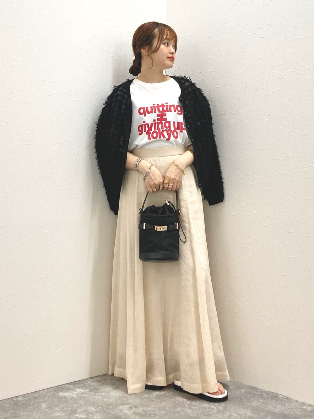 ホワイト系のTシャツ/カットソー、ベージュ系のスカート、ブラック系のカーディガン/ボレロを着用したレディースの夏コーディネートの6枚目の写真