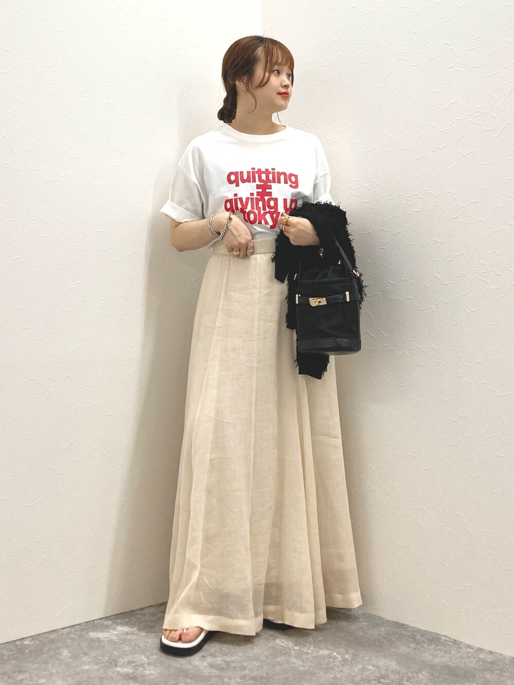 ホワイト系のTシャツ/カットソー、ベージュ系のスカート、ブラック系のカーディガン/ボレロを着用したレディースの夏コーディネートの5枚目の写真