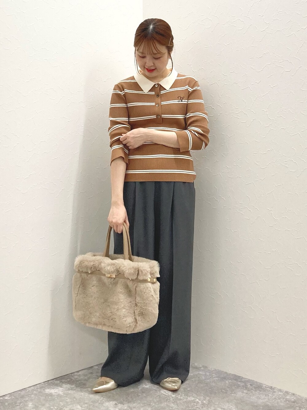 グレー系のその他パンツ、ブラウン系のニット/セーター、ベージュ系のトートバッグを着用したレディースの秋コーディネートの9枚目の写真