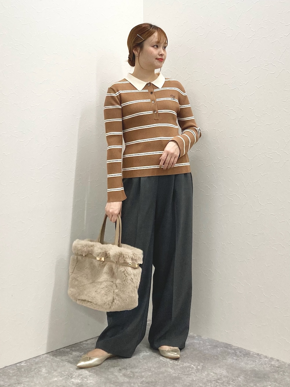 グレー系のその他パンツ、ブラウン系のニット/セーター、ベージュ系のトートバッグを着用したレディースの秋コーディネートの2枚目の写真
