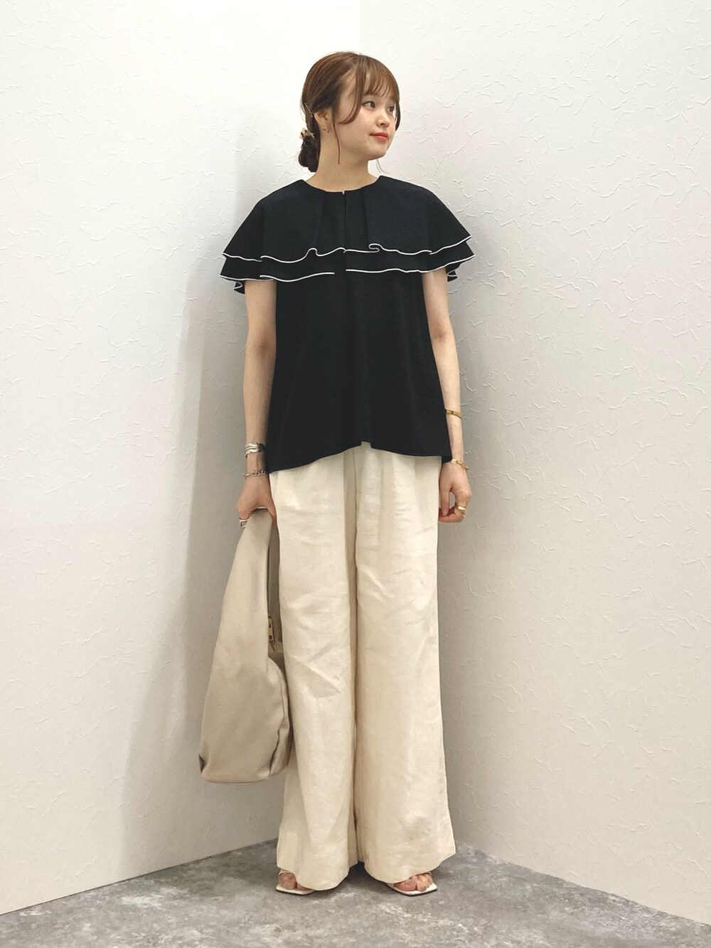 ブラック系のシャツ/ブラウス、ホワイト系のその他パンツ、ベージュ系のショルダーバッグを着用したレディースの夏コーディネートの3枚目の写真