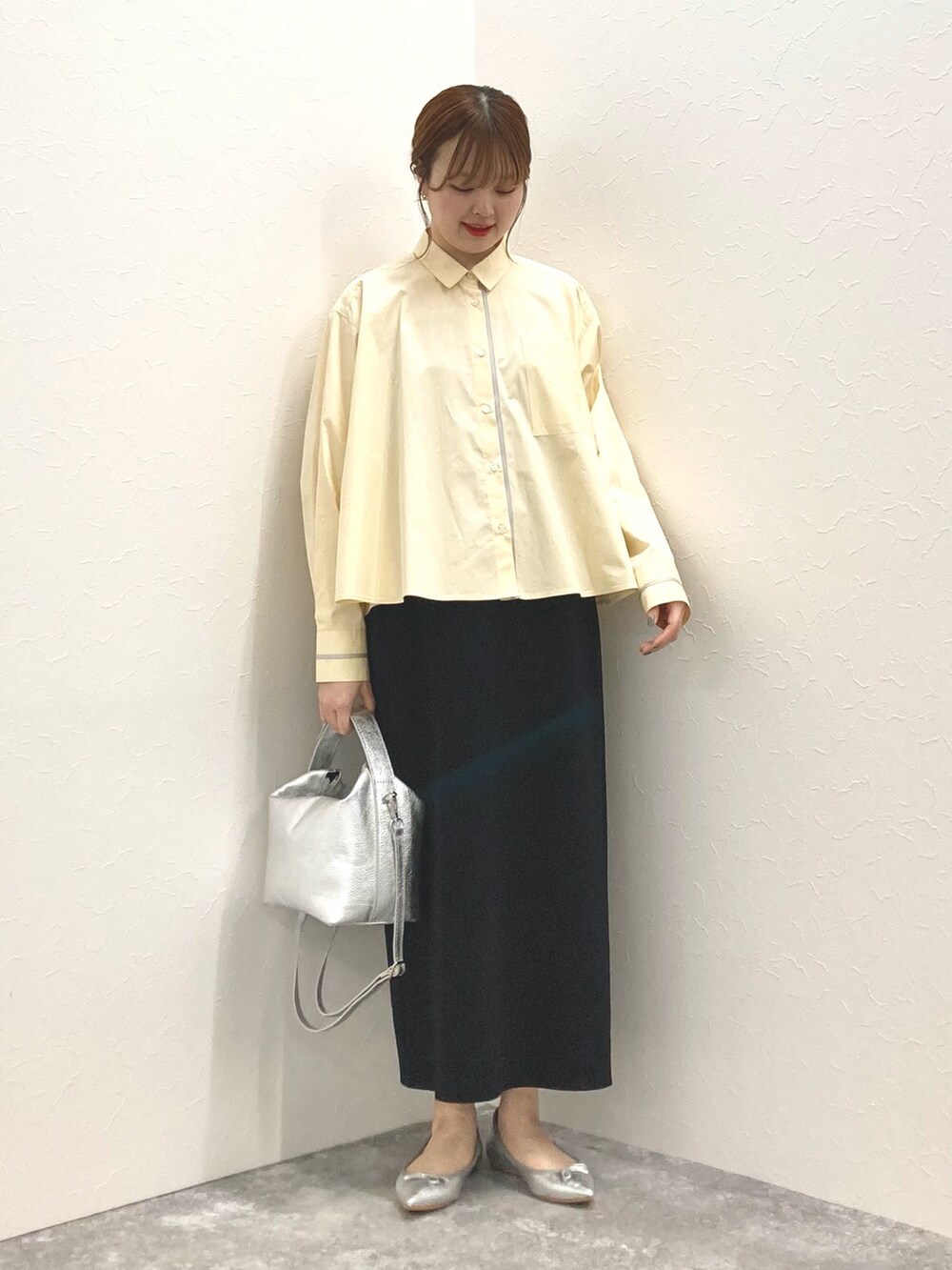 シルバー系のショルダーバッグ、イエロー系のシャツ/ブラウス、ブラック系のスカートを着用したレディースの春コーディネートの6枚目の写真