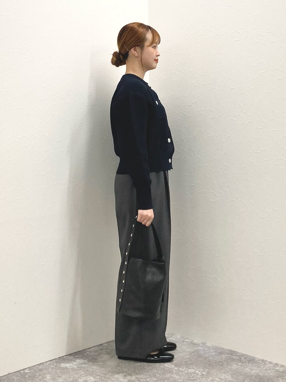 ブラック系のショルダーバッグ、ブラック系のパンプス、ブルー系のカーディガン/ボレロを着用したレディースの秋コーディネートの6枚目の写真