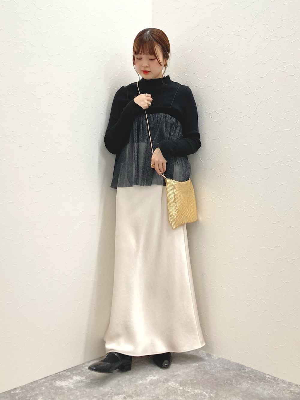 ホワイト系のニット/セーター、ブラック系のシャツ/ブラウス、ゴールド系のクラッチバッグを着用したレディースの秋コーディネートの8枚目の写真