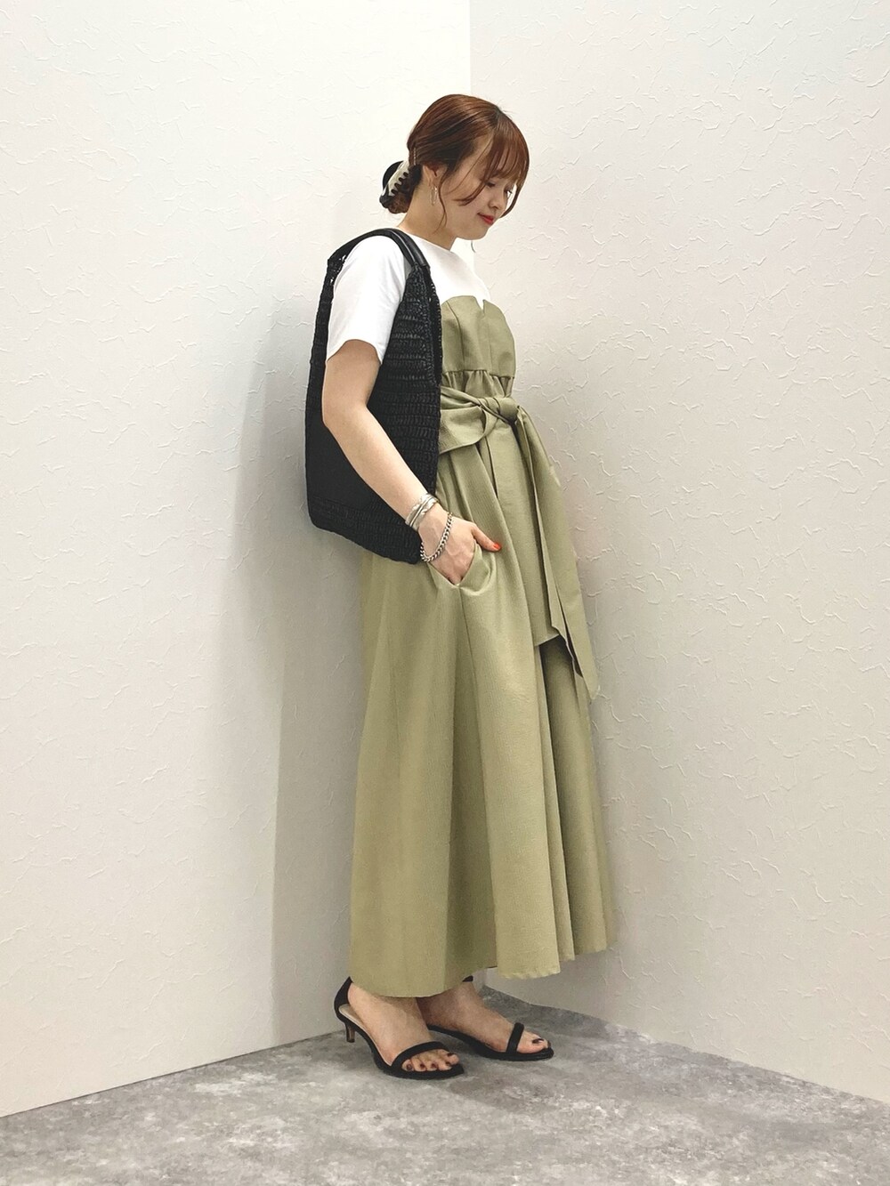 グリーン系のワンピース、ブラック系のサンダル、ブラック系のかごバッグを着用したレディースの春コーディネートの7枚目の写真