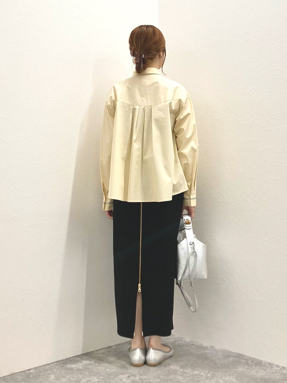 シルバー系のショルダーバッグ、イエロー系のシャツ/ブラウス、ブラック系のスカートを着用したレディースの春コーディネートの4枚目の写真