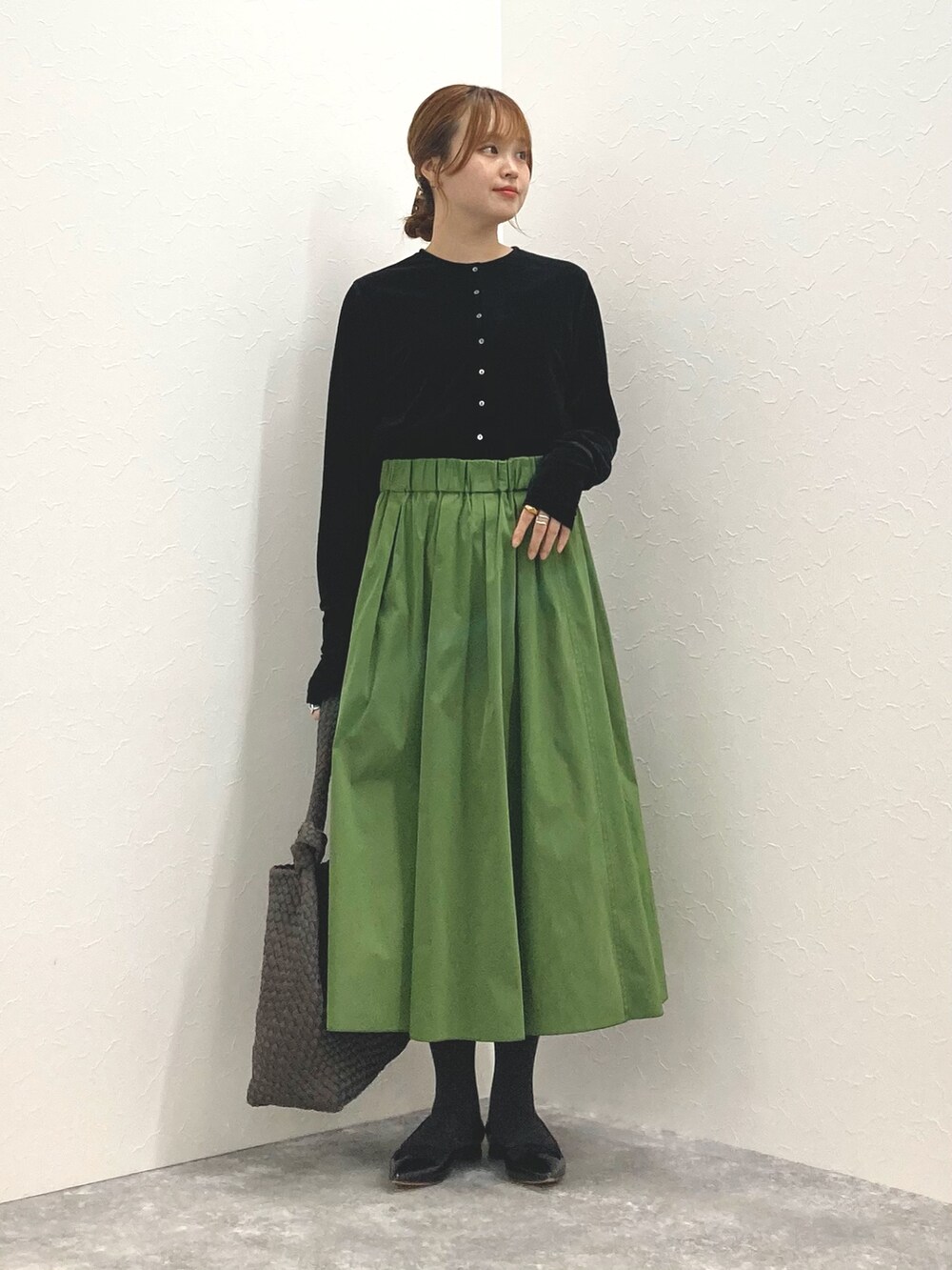 ブラック系のカーディガン/ボレロ、グリーン系のスカート、グレー系のショルダーバッグを着用したレディースの秋コーディネートの2枚目の写真