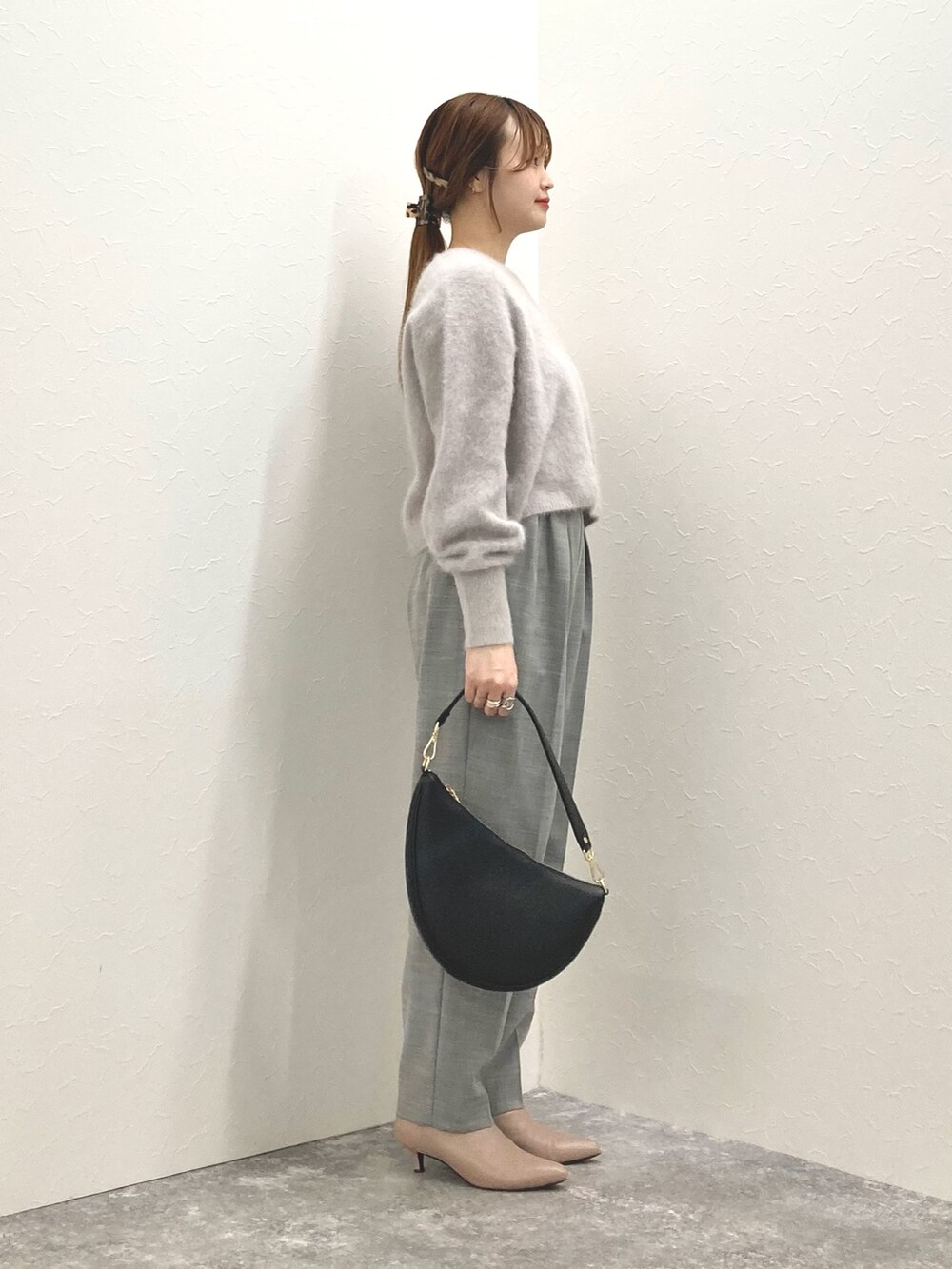 ベージュ系のニット/セーター、ブラック系のショルダーバッグ、グレー系のその他パンツを着用したレディースの冬コーディネートの5枚目の写真