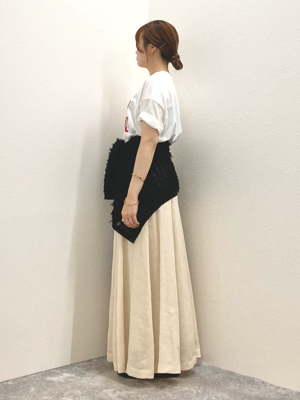 ホワイト系のTシャツ/カットソー、ベージュ系のスカート、ブラック系のカーディガン/ボレロを着用したレディースの夏コーディネートの2枚目の写真