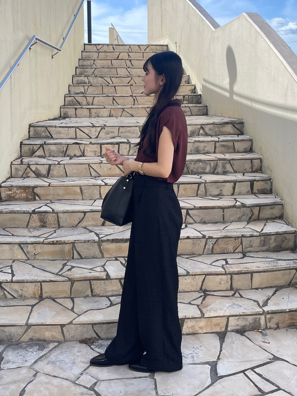 レッド系のシャツ/ブラウス、ブラック系のその他パンツ、ブラック系のハンドバッグを着用したレディースの秋コーディネートの2枚目の写真