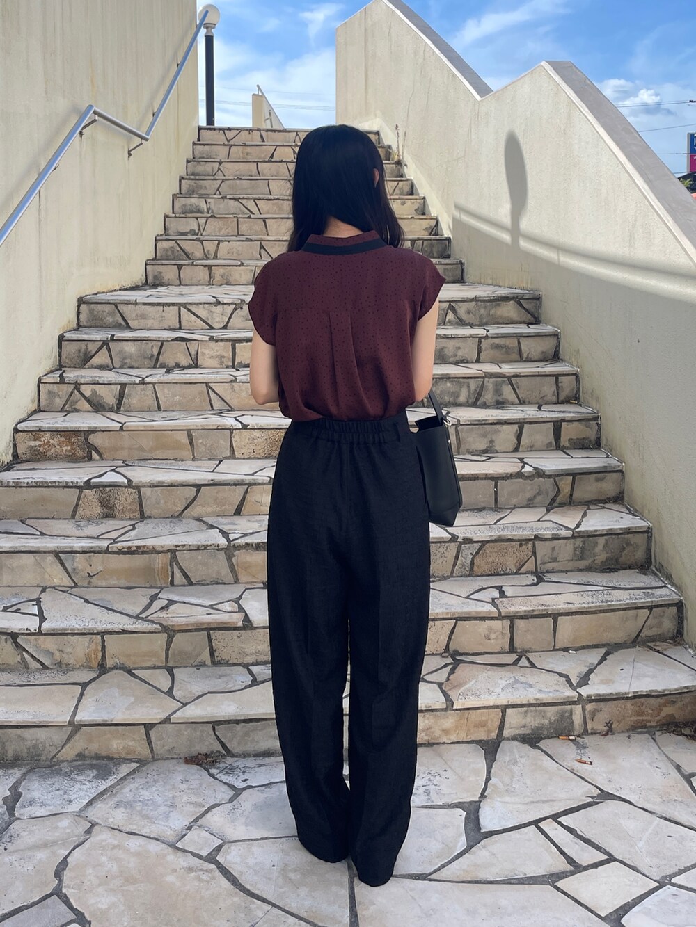 レッド系のシャツ/ブラウス、ブラック系のその他パンツ、ブラック系のハンドバッグを着用したレディースの秋コーディネートの3枚目の写真