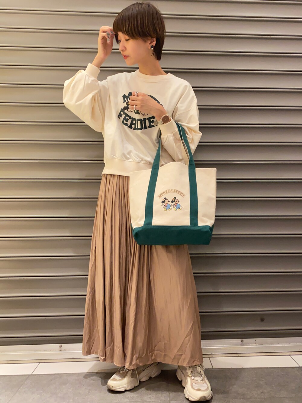 ブラウン系のスカート、ホワイト系のスウェット、ベージュ系のトートバッグを着用したレディースの冬コーディネートの2枚目の写真