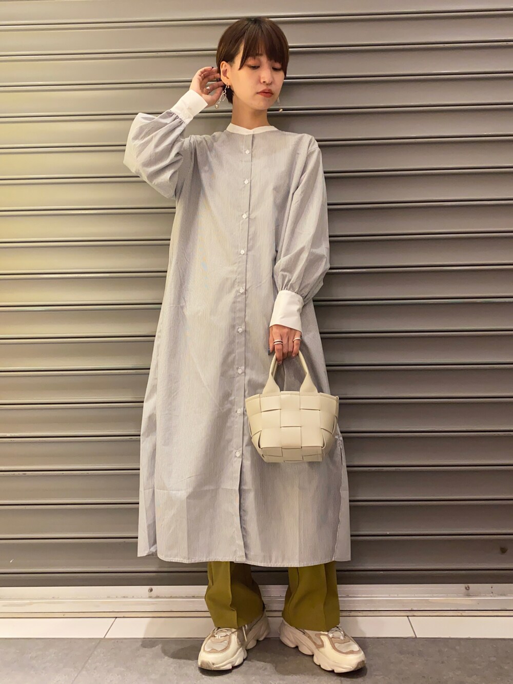 イエロー系のその他パンツ、グレー系のワンピース、ベージュ系のショルダーバッグを着用したレディースの秋コーディネートの2枚目の写真