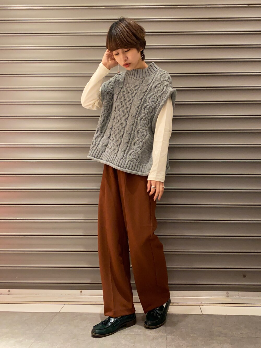 ブラウン系のその他パンツ、ホワイト系のTシャツ/カットソー、グレー系のベストを着用したレディースの冬コーディネートの3枚目の写真