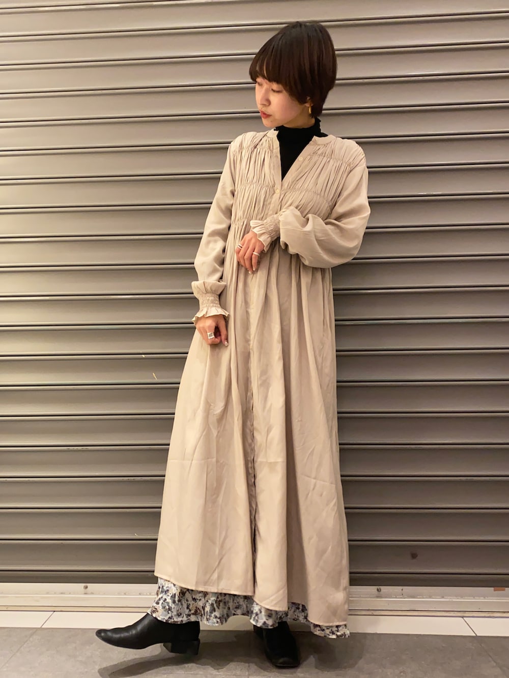 ベージュ系のワンピース、ブラック系のその他トップス、ブルー系のスカートを着用したレディースの冬コーディネートの2枚目の写真