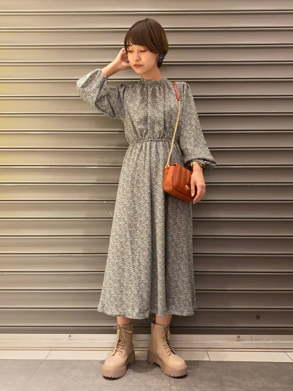 グリーン系のワンピース、オレンジ系のショルダーバッグ、ベージュ系のブーツを着用したレディースの秋コーディネートの2枚目の写真