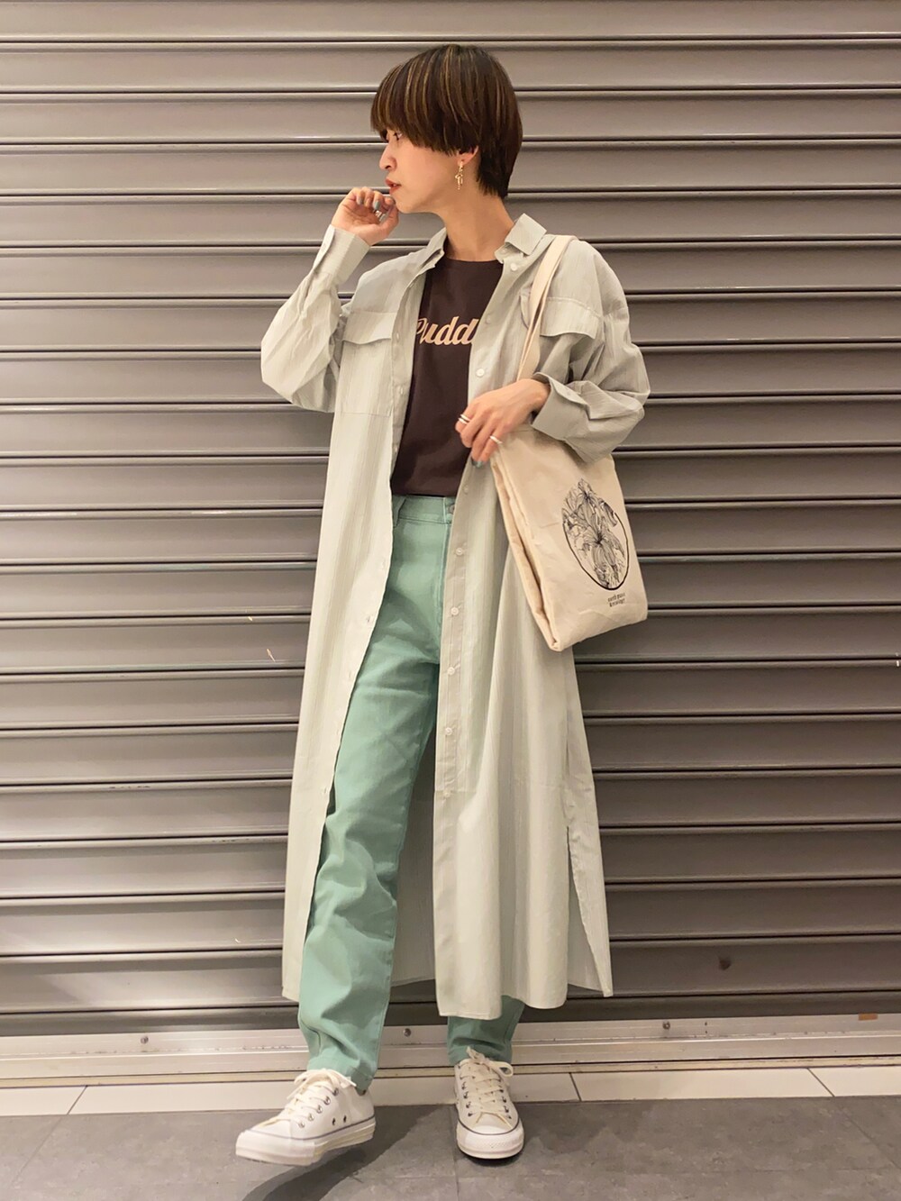 ホワイト系のトートバッグ、グリーン系のシャツワンピース、ブラウン系のチュニックを着用したレディースの春コーディネートの2枚目の写真