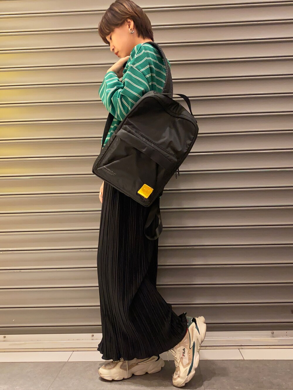 グリーン系のTシャツ/カットソー、ブラック系のトートバッグ、ブラック系のスカートを着用したレディースの冬コーディネートの3枚目の写真