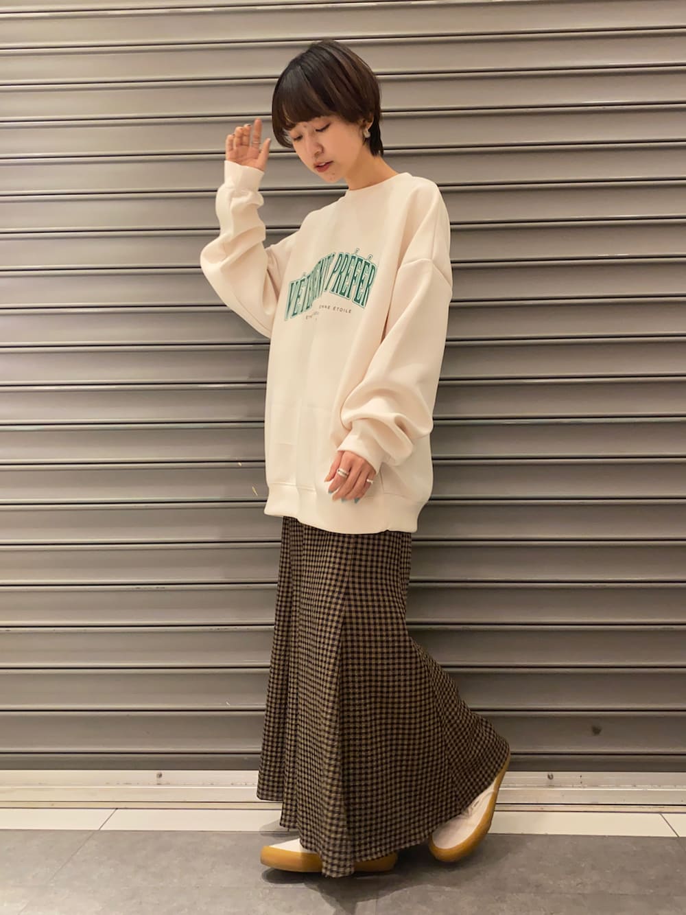 ホワイト系のスウェット、ブラウン系のスカートを着用したレディースの春コーディネートの2枚目の写真