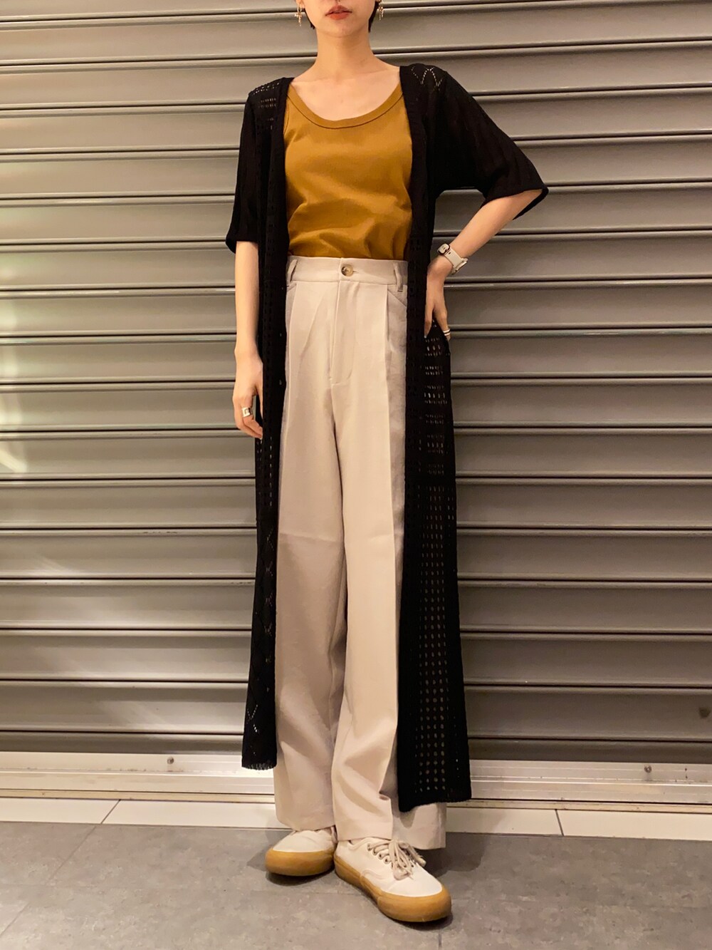 ベージュ系のその他パンツ、イエロー系のタンクトップ、ブラック系のワンピースを着用したレディースの春コーディネートの2枚目の写真