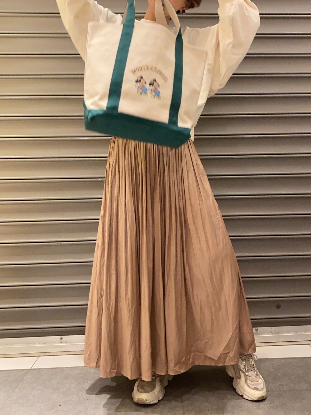 ブラウン系のスカート、ホワイト系のスウェット、ベージュ系のトートバッグを着用したレディースの冬コーディネートの4枚目の写真