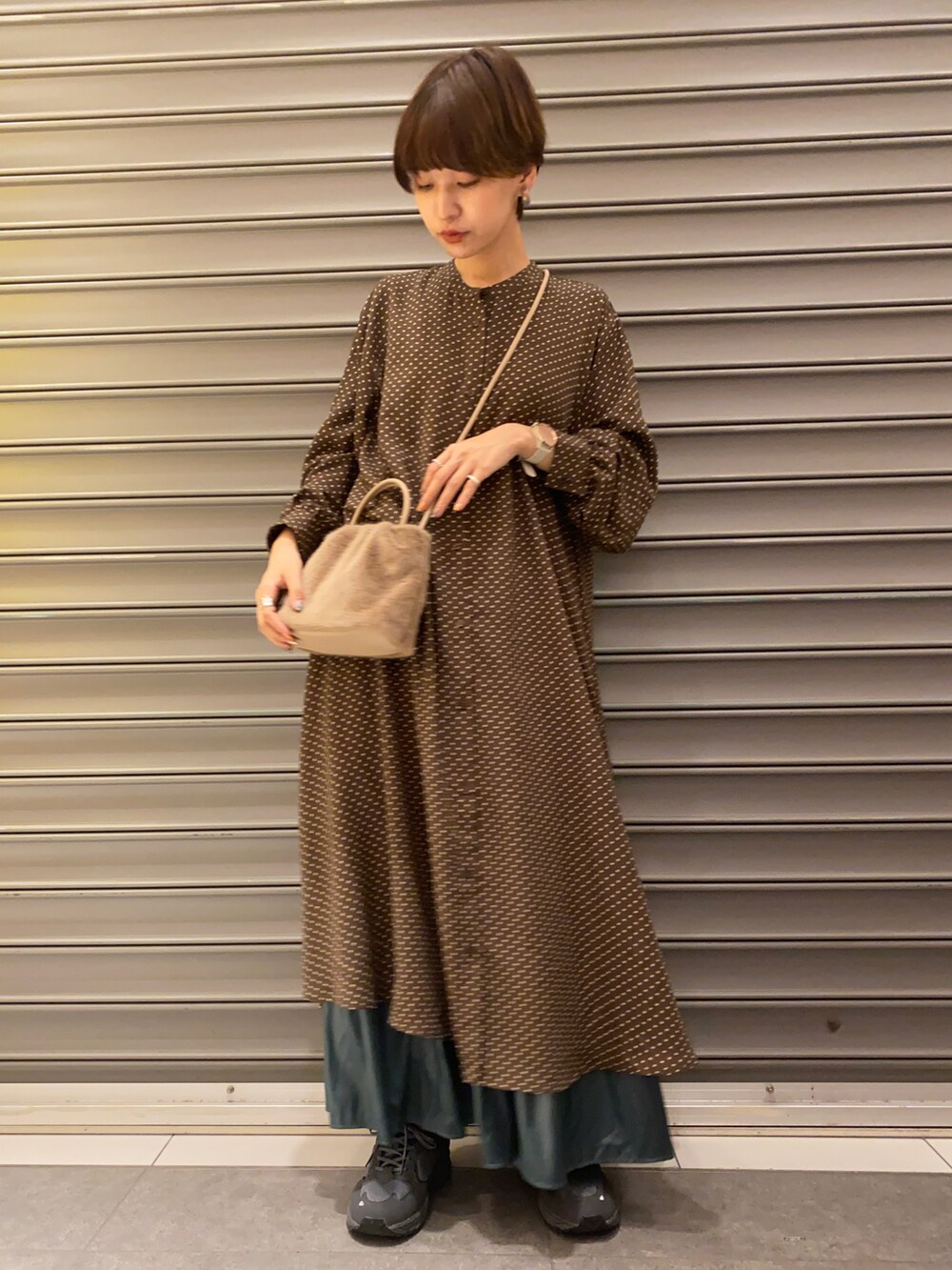 ブラウン系のワンピース/ドレス、グリーン系のスカート、ブラウン系のトートバッグを着用したレディースの秋コーディネートの2枚目の写真
