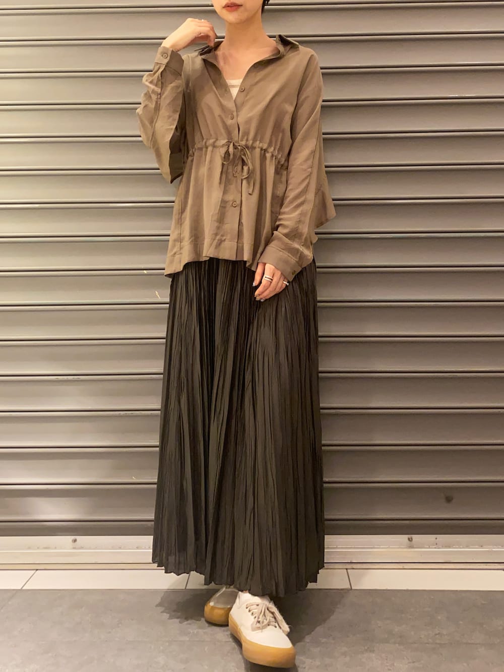 グレー系のスカート、ブラウン系のシャツ/ブラウスを着用したレディースの春コーディネートの3枚目の写真