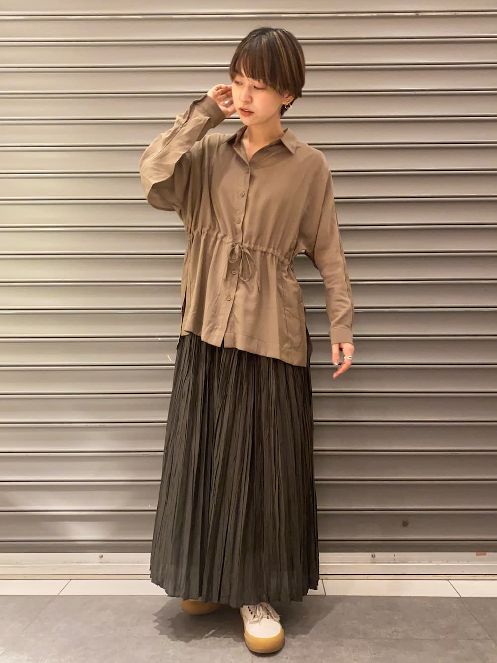 グレー系のスカート、ブラウン系のシャツ/ブラウスを着用したレディースの春コーディネートの2枚目の写真