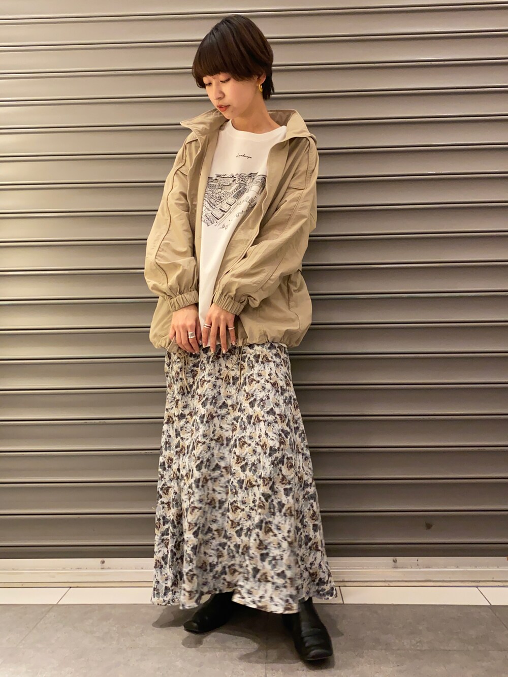 ブルー系のスカート、ベージュ系のナイロンジャケット、その他のTシャツ/カットソーを着用したレディースの冬コーディネートの2枚目の写真