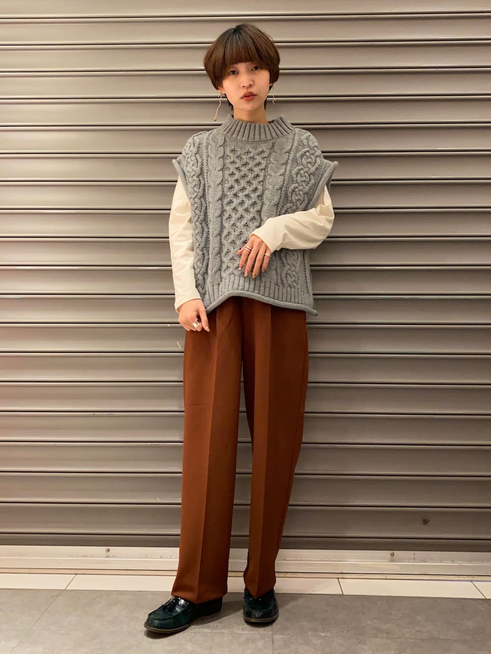 ブラウン系のその他パンツ、ホワイト系のTシャツ/カットソー、グレー系のベストを着用したレディースの冬コーディネートの2枚目の写真