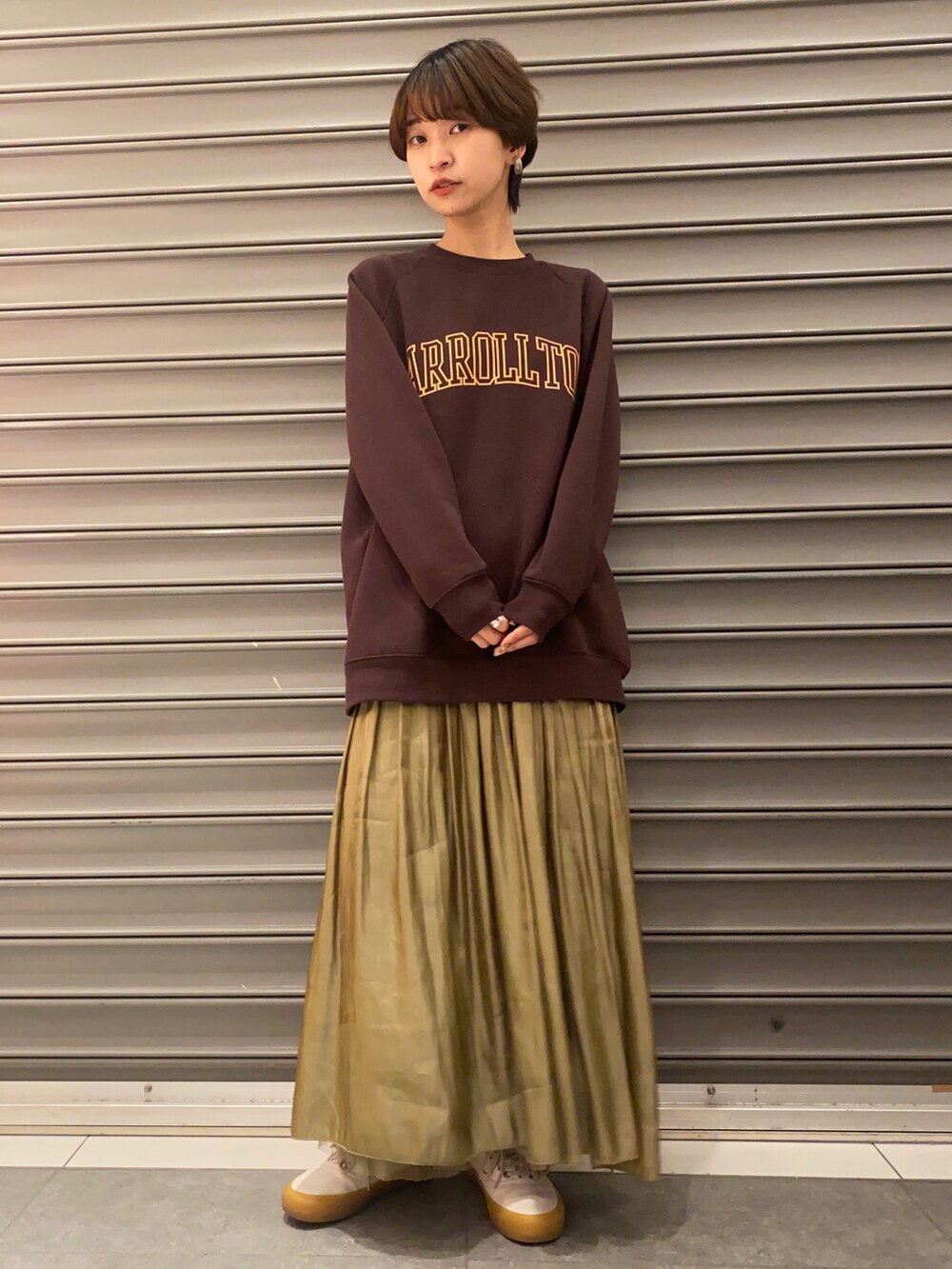 ブラウン系のTシャツ/カットソー、ベージュ系のマウンテンパーカー、イエロー系のスカートを着用したレディースの冬コーディネートの4枚目の写真