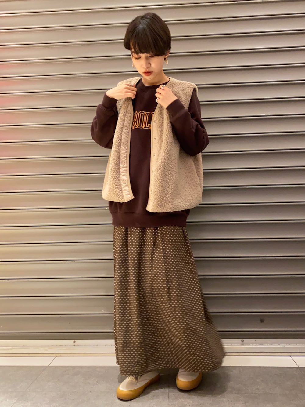 ベージュ系のベスト、ブラウン系のTシャツ/カットソー、ブラウン系のスカートを着用したレディースの冬コーディネートの2枚目の写真