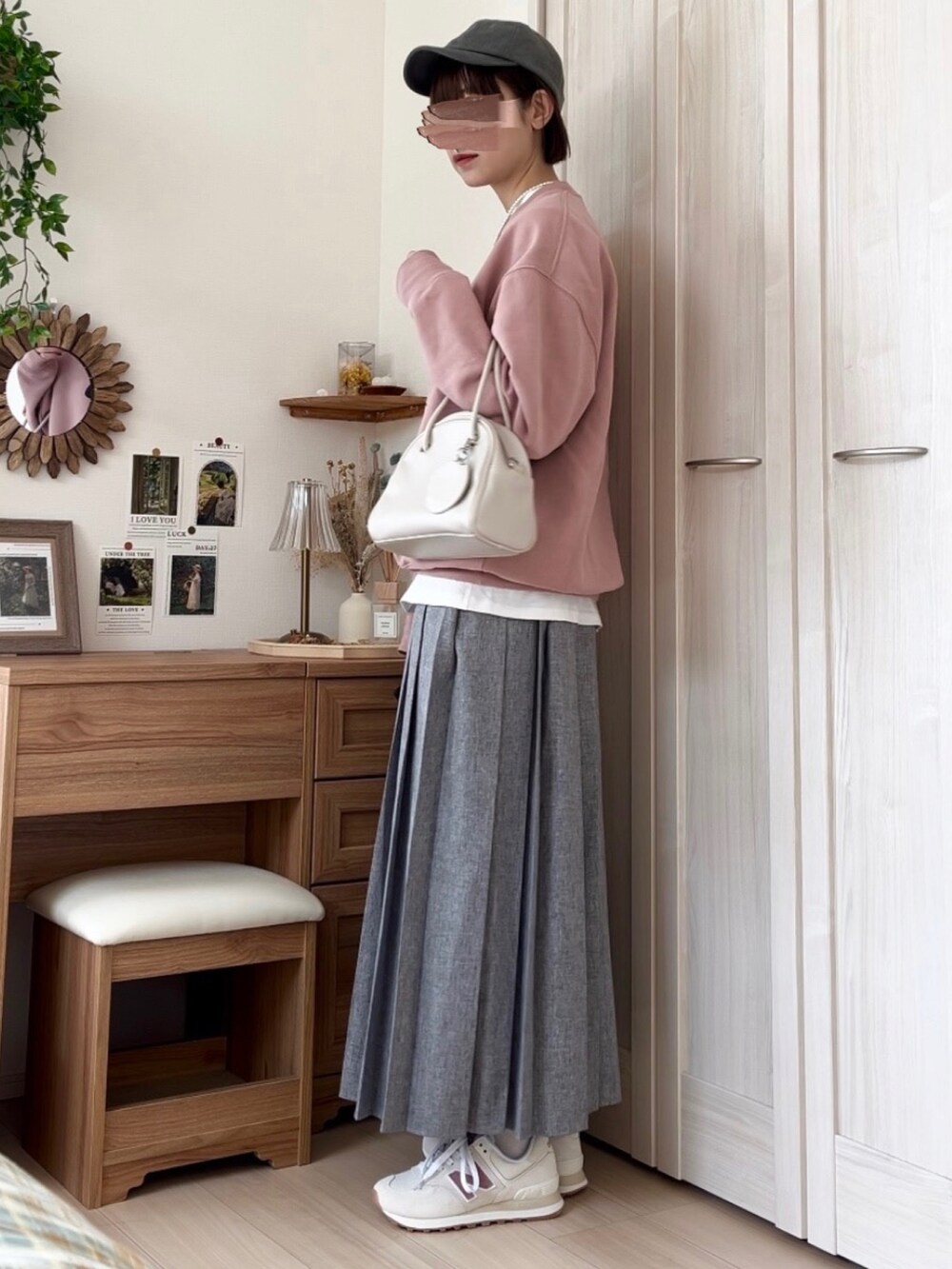 ピンク系のスウェット、ブラウン系のスカート、ホワイト系のボストンバッグを着用したレディースの春コーディネートの2枚目の写真