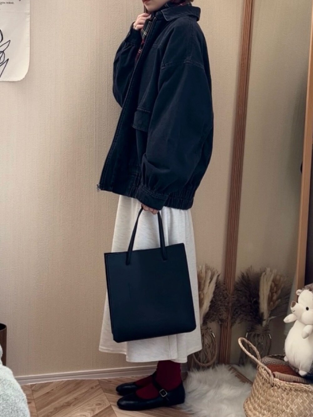 ブラック系のブルゾン、グレー系のワンピース、ブラック系のトートバッグを着用したレディースの冬コーディネートの3枚目の写真