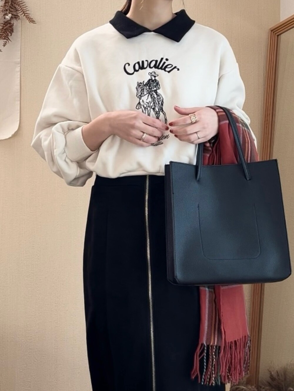 ホワイト系のスウェット、ブラック系のスカート、ブラック系のトートバッグを着用したレディースの冬コーディネートの2枚目の写真