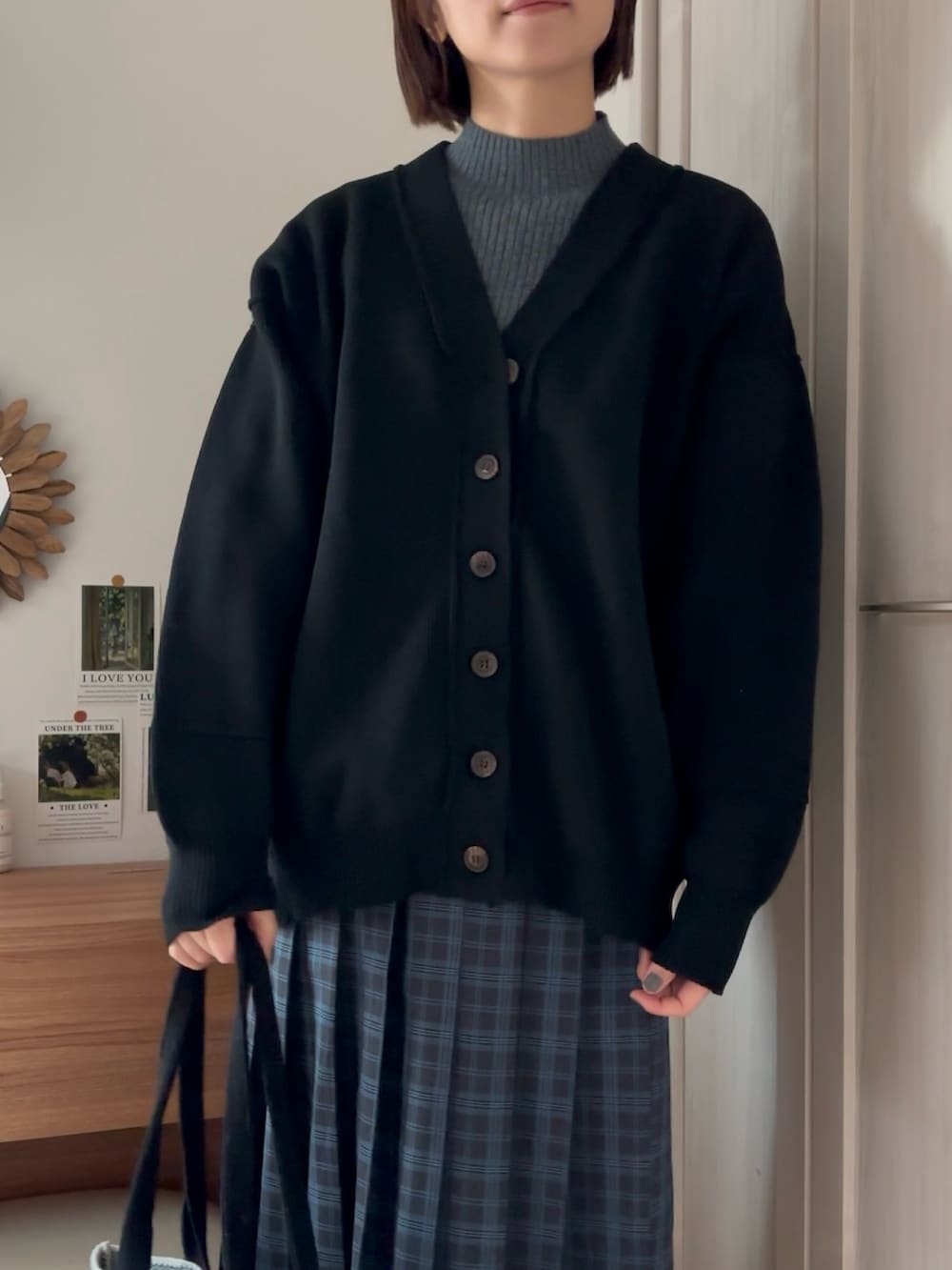 ブラック系のカーディガン/ボレロ、ブラック系のスカート、グレー系のTシャツ/カットソーを着用したレディースの冬コーディネートの2枚目の写真