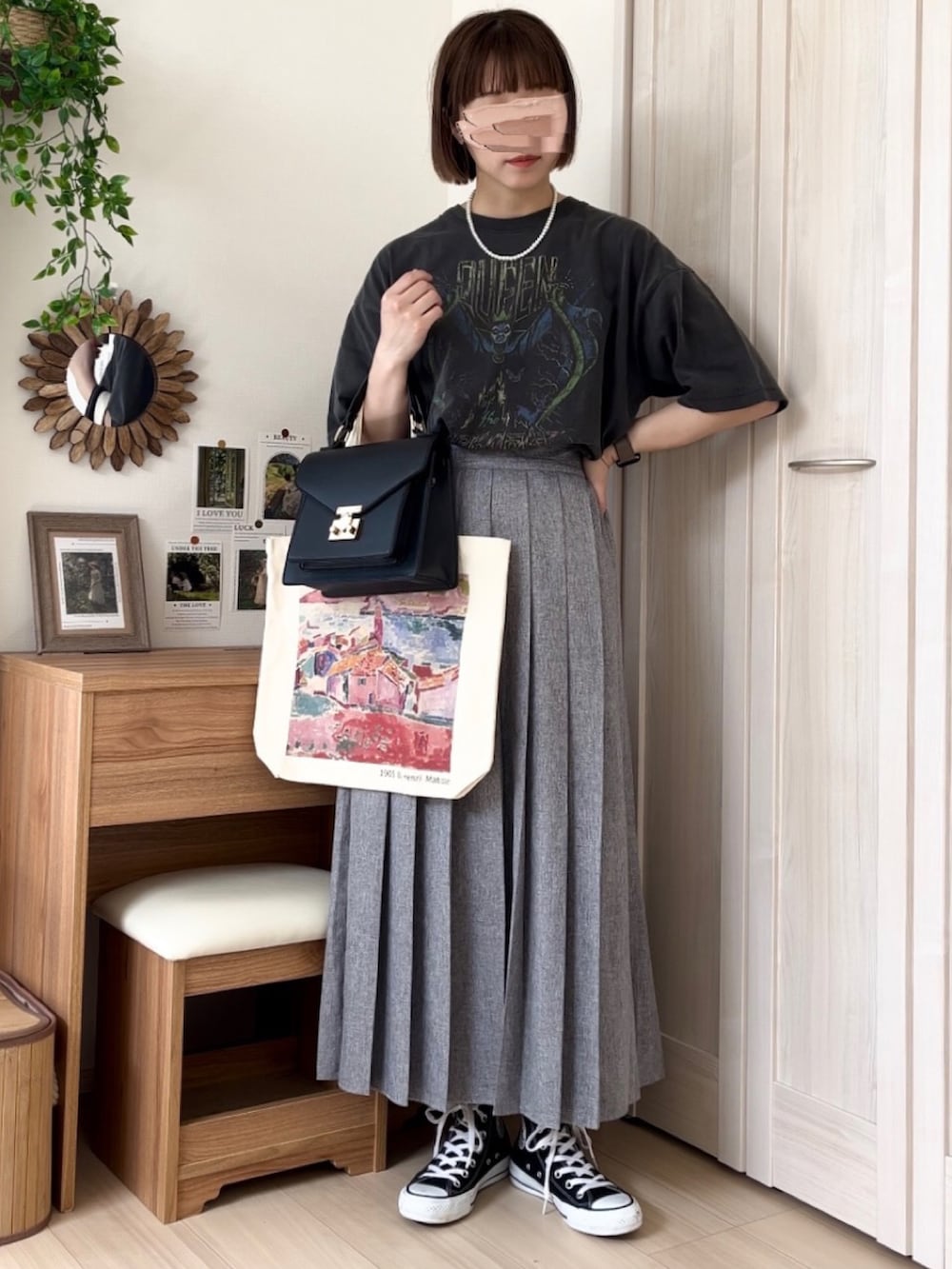 グレー系のTシャツ/カットソー、ブラック系のカーディガン/ボレロ、グレー系のスカートを着用したレディースの春コーディネートの4枚目の写真