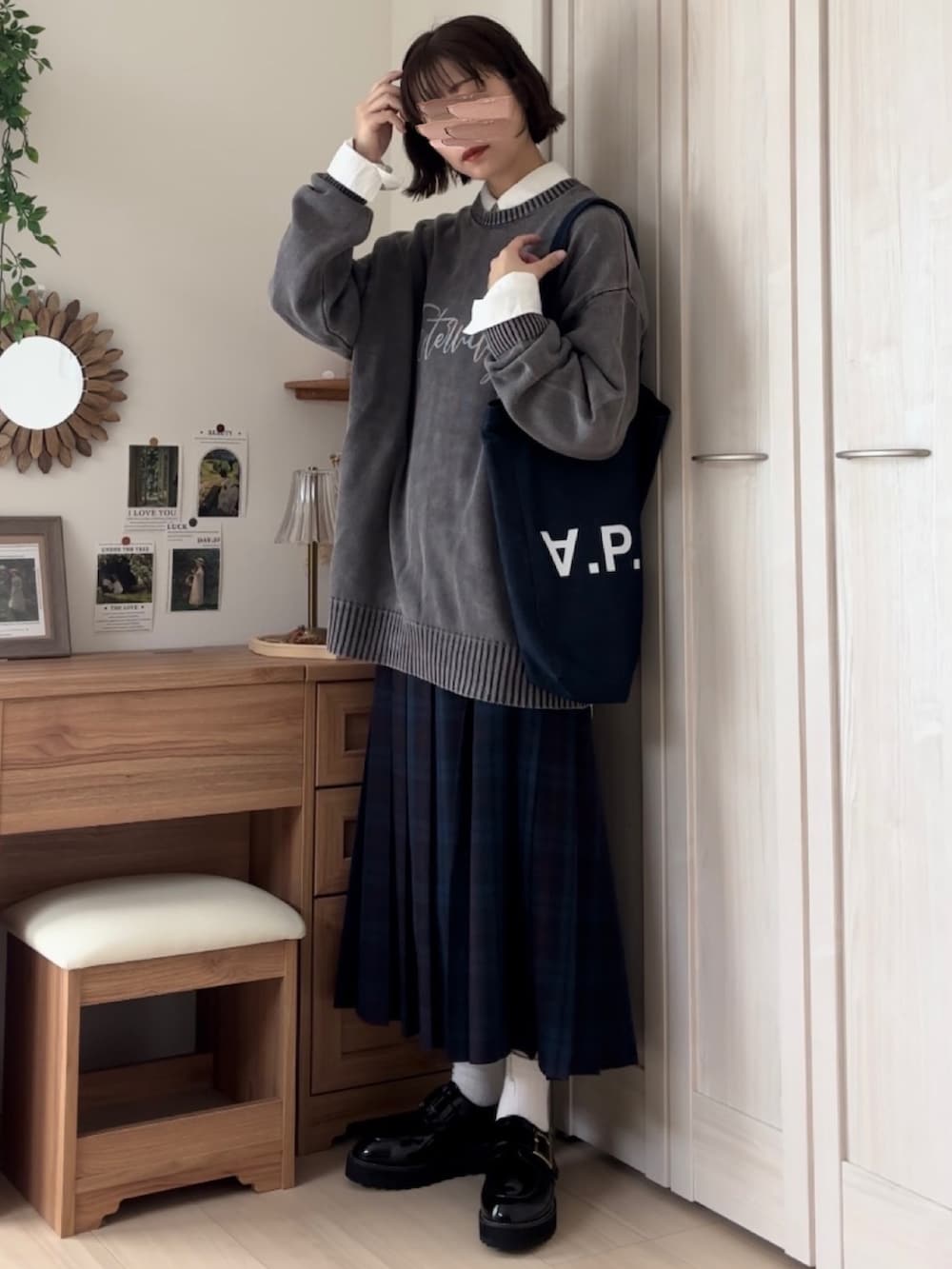 ブラック系のニット/セーター、ブルー系のスカート、ブルー系のトートバッグを着用したレディースの秋コーディネートの4枚目の写真