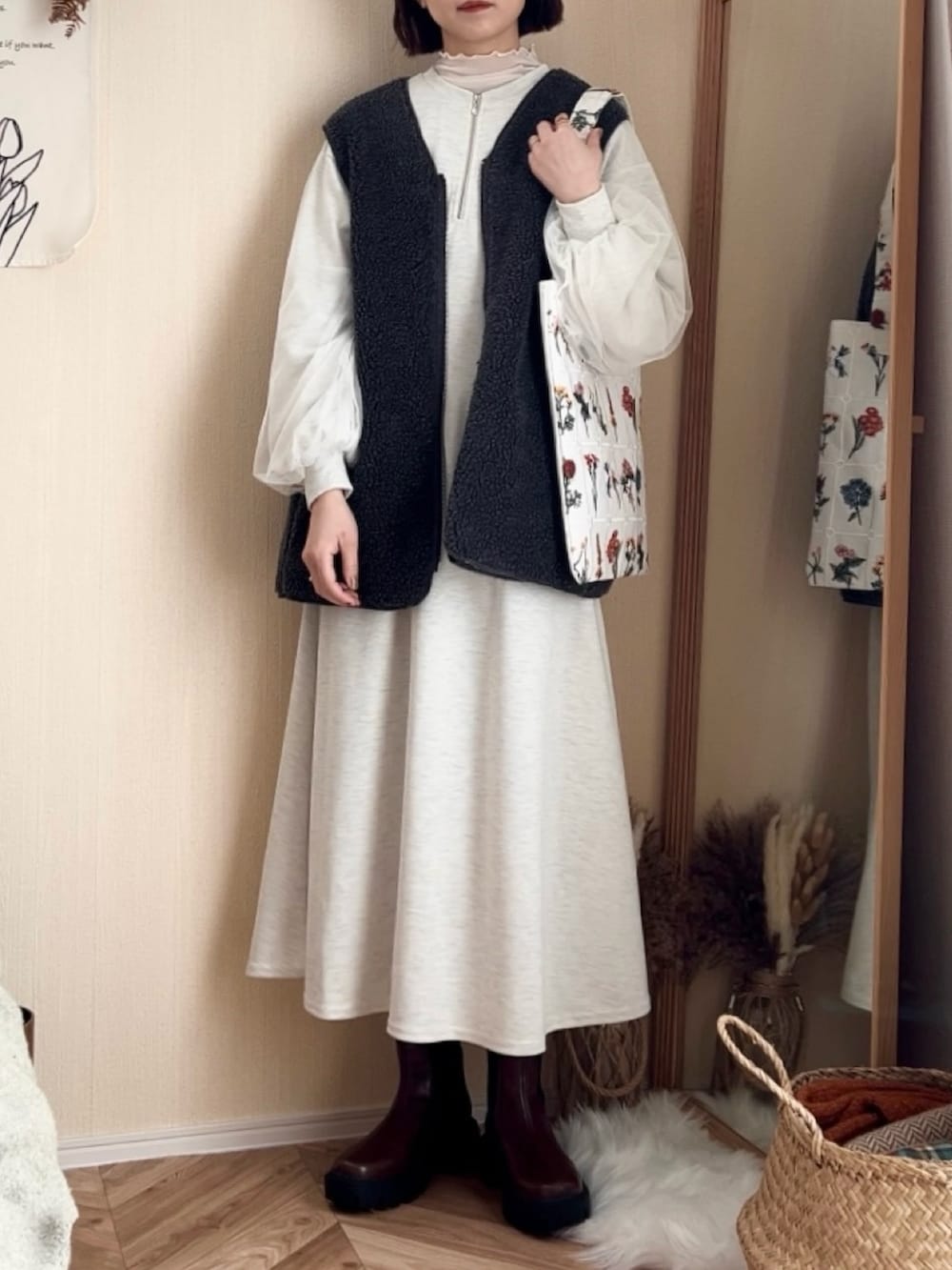 グレー系のワンピース、グレー系のベスト、ブラウン系のブーツを着用したレディースの冬コーディネートの3枚目の写真