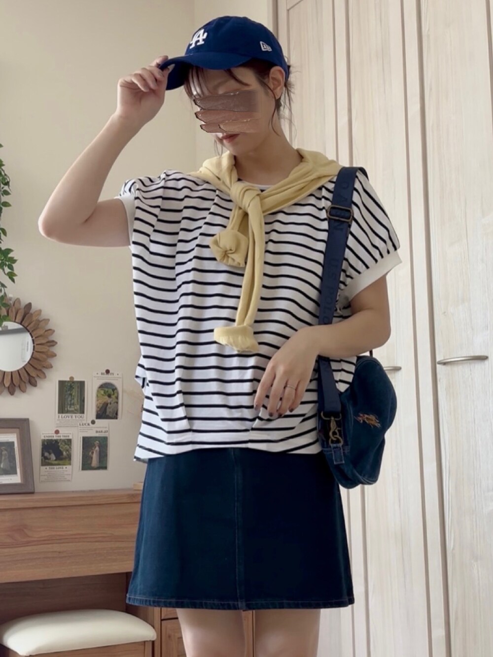 ホワイト系のTシャツ/カットソー、ブラック系のバレエシューズ、ブルー系のデニムスカートを着用したレディースの夏コーディネートの4枚目の写真